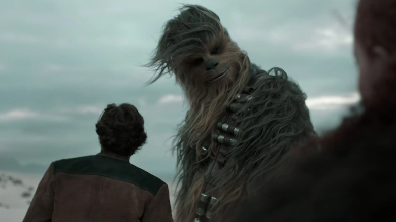 Joonas Suotamo as Chewbacca bids farewell to Enfys Nest as he prepares to leave with Alden Ehrenreich's Han in Solo