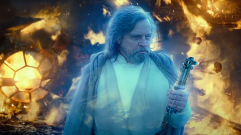 Mark Hamill as Luke Skywalker's Force spirit catches his tangible lightsaber in Star Wars:The Rise of Skywalker