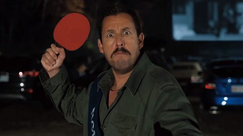 Hubie Dubois (Adam Sandler) holding a paddle at a drive-in in Hubie Halloween