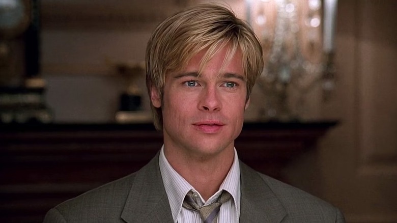 Joe Black (Brad Pitt) smiles by a mantle in Meet Joe Black