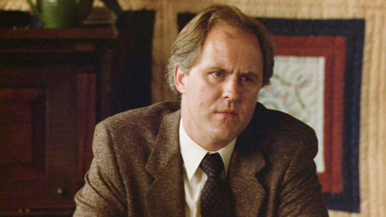 Reverend Shaw Moore (John Lithgow) sits contemplatively in his office in Footloose (1984)