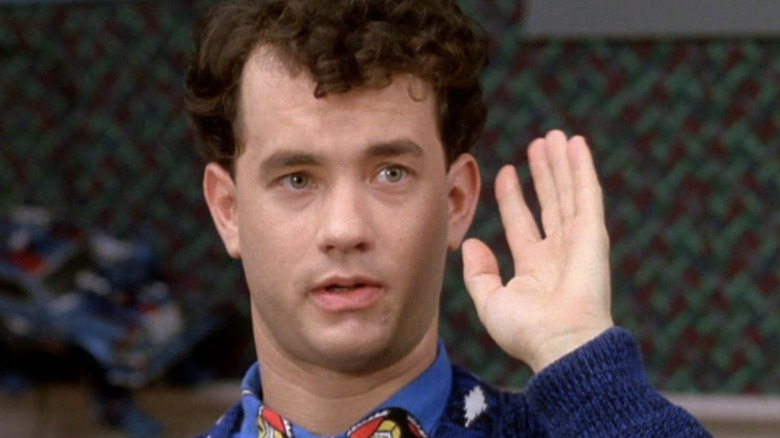 Josh Baskin (Tom Hanks) raises his hand to speak in Big