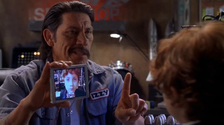Danny Trejo as Uncle Machete holds up a screen displaying Daryl Sabara as Juni Cortez, in Spy Kids