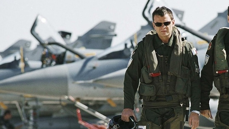 Sébastian Vallois (Clovis Cornillac) walks away from a line of fighter jets in Sky Fighters