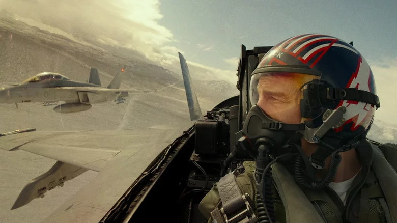 Pete Mitchell (Tom Cruise) looks at a fighter plane flying beside him in the clouds in Top Gun: Maverick