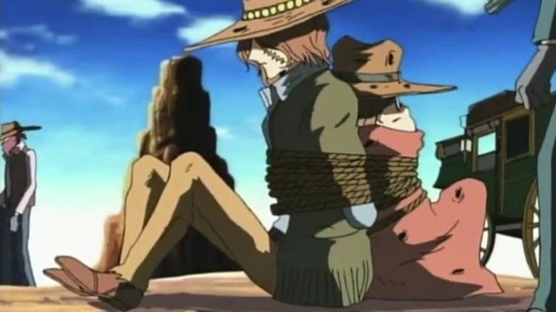 Franklin Harlock and Tochiro Oyama are tied back-to-back by a stagecoach in Gun Frontier