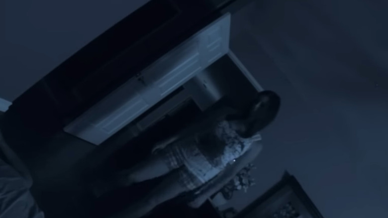 Katie Featherston as Katie, possessed and standing over a body in Paranormal Activity