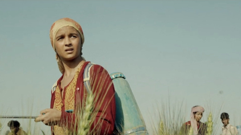 Alia Bhatt as Bauria, wearing red and working in the fields in Udta Punjab