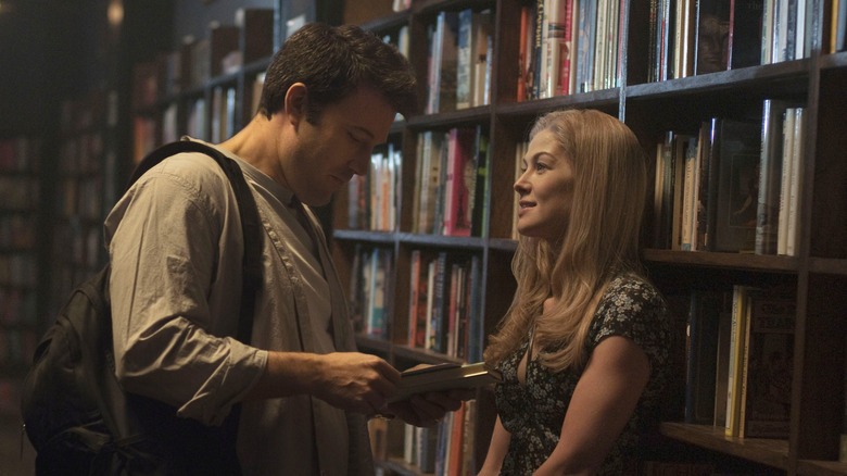 Nick Dunne (Ben Affleck) and Amy Dunne (Rosamund Pike) flirt with each other in a library in Gone Girl
