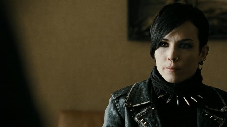 Lisbeth Salander (Noomi Rapace) stands wearing studded leather and spikes in The Girl with the Dragon Tattoo (2009)