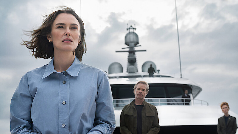 Lo Blacklock (Keira Knightley) stands at the stern of a ship with the crew watching her in The Woman in Cabin 10