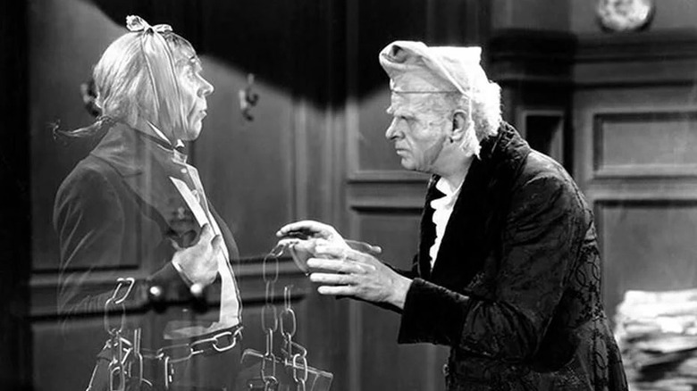 Ebenezer Scrooge (Reginald Owen) reaches out to the ghost of Marley's ghost (Leo G. Carroll) in A Christmas Carol (1938)