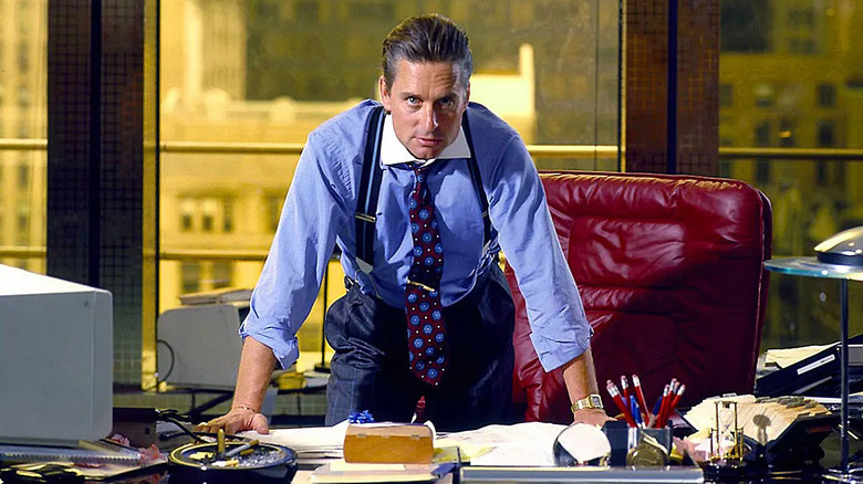 Michael Douglas as Gordon Gekko standing over his desk in Wall Street