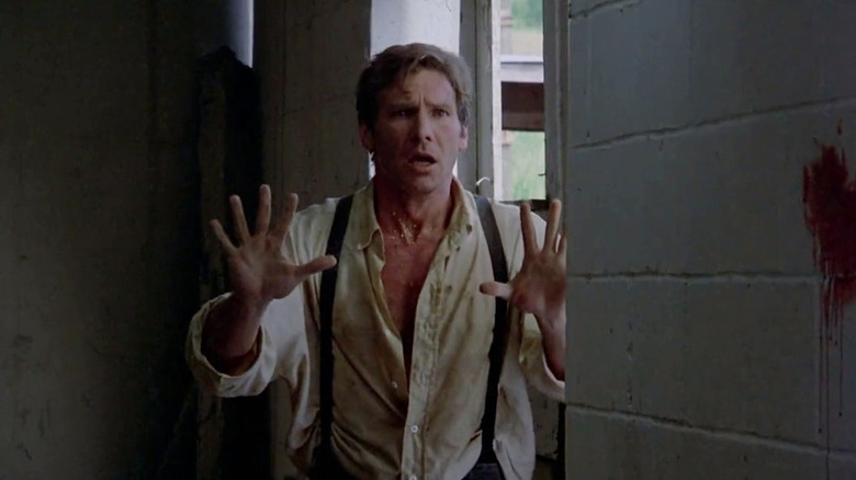 Harrison Ford as John Book, looking scared with his hands up in Witness