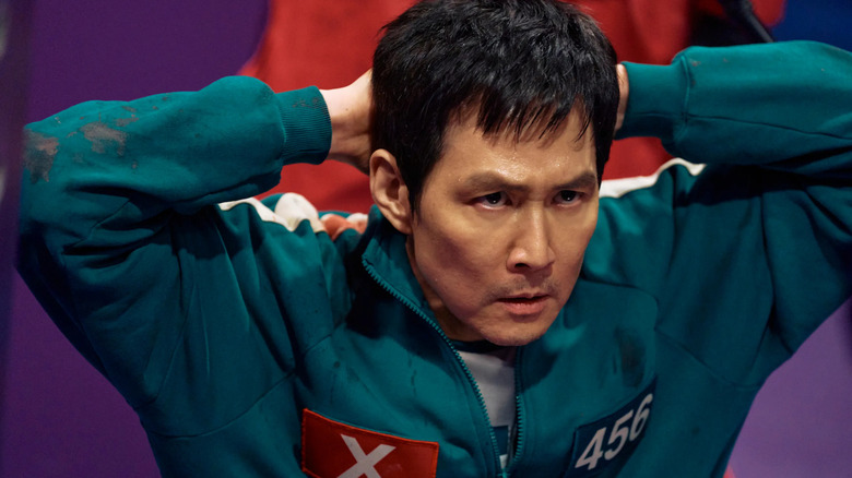 Seong Gi-hun (Lee Jung-jae) with hands behind his head on Squid Game