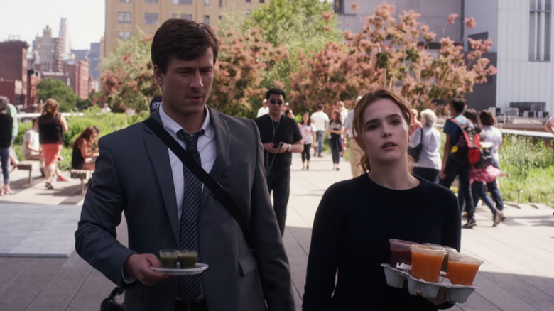 Harper (Zoey Deutch) and Charlie (Glen Powell) walking with coffee in Set It Up