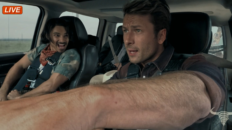 Tyler (Glen Powell) in truck chasing tornado with crew in Twisters