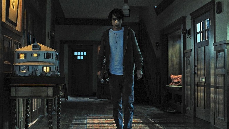 Alex Wolff as Peter Graham, walking down a hallway in his home in Hereditary