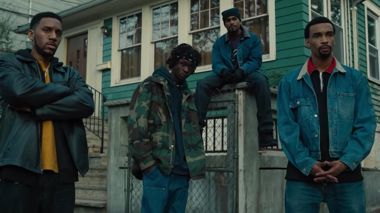 The cast of Wu-Tang: An American Saga portraying the titular music group posed outside of a house in the Hulu original series