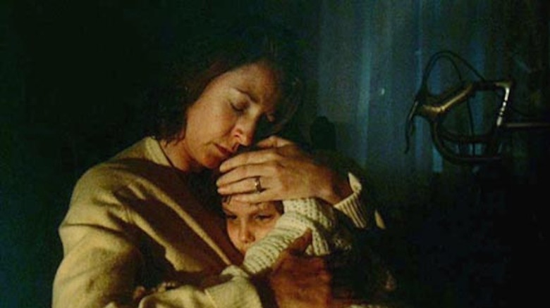 Jane Alexander as Carol Weatherly cradles Lukas Haas as her sick son Scottie in Testament