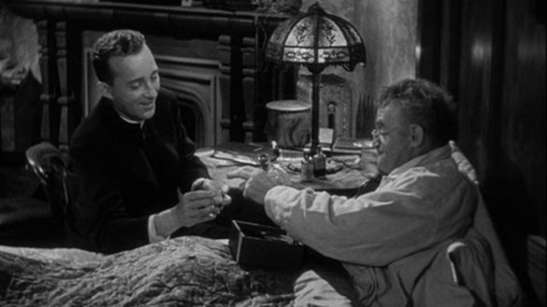 Father Chuck O'Malley (Bing Crosby) speaks with Father Fitzgibbon (Barry Fitzgerald) by his bed in Going My Way