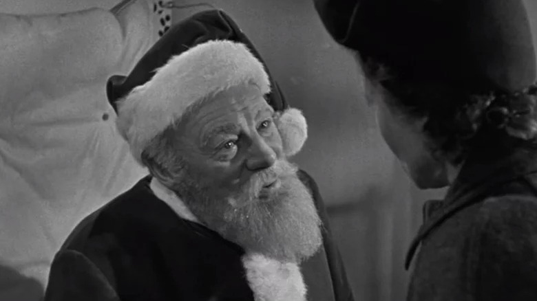 Kris Kringle (Edmund Gwenn) looks up smiling in his Santa Claus costume in Miracle on 34th Street