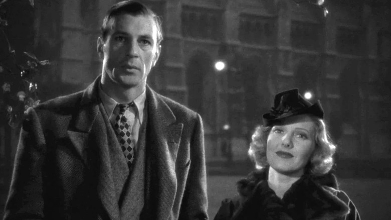 Longfellow Deeds (Gary Cooper) stands next to Babe Bennett (Jean Arthur) on the street in Mr. Deeds Goes to Town