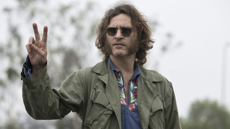 Joaquin Phoenix as Larry "Doc" Sportello holding up a peace sign in Inherent Vice