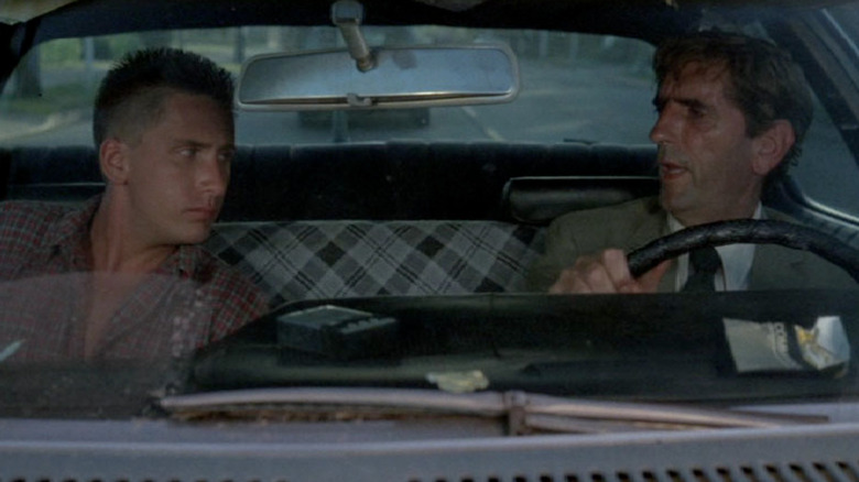 Emilio Estevez as Otto Maddox listening to Harry Dean Stanton as Bud talkin the front seat of a car in Repo Man
