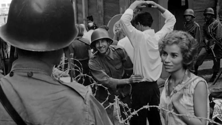 Samia Kerbash as Fathia flirting with a guard in The Battle of Algiers