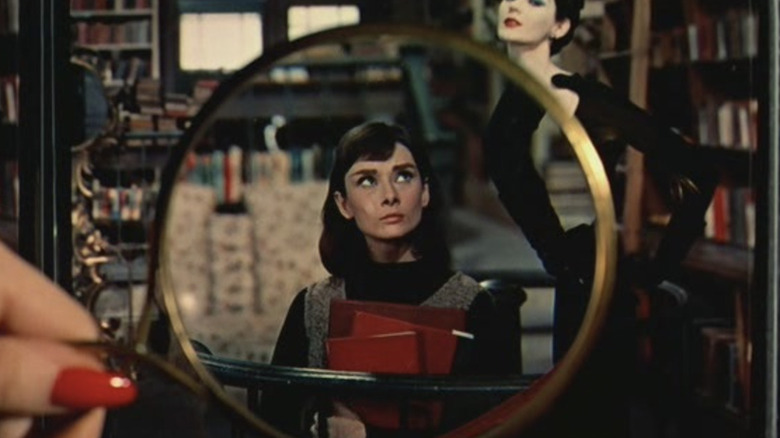 Audrey Hepburn as Jo Stockton seen through a magnifying glass in a bookstore in Funny Face