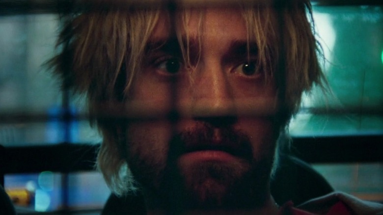 Connie Nikas (Robert Pattinson) in the back of a cop car in Good Time