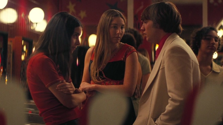 Danielle and Este Haim as Danielle and Este talking to Cooper Hoffman as Gary in an arcade in Licorice Pizza