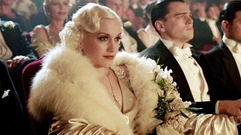 Gwen Stefani as Jean Harlow sitting next to Leonardo DiCaprio as Howard Hughes in a theater in The Aviator