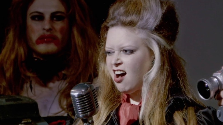 Natasha Lyonne snarling into old-school microphone in All About Evil