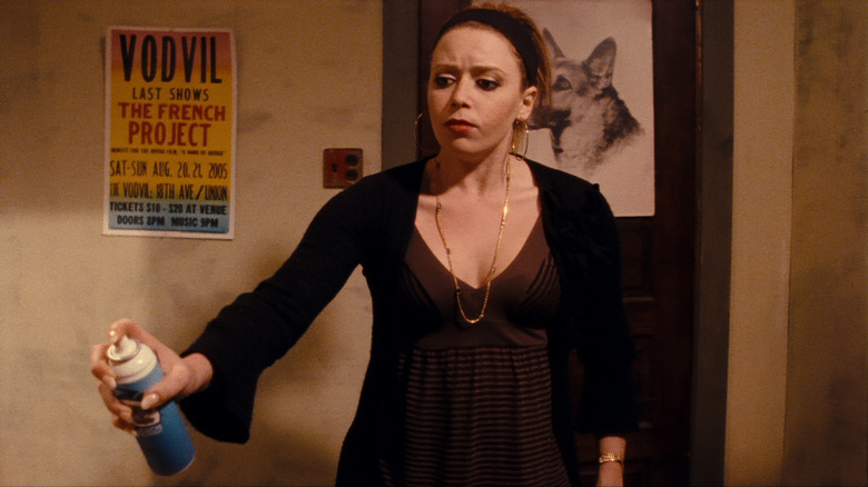 Natasha Lyonne with hair up holding spray can in The Immaculate Conception of Little Dizzle
