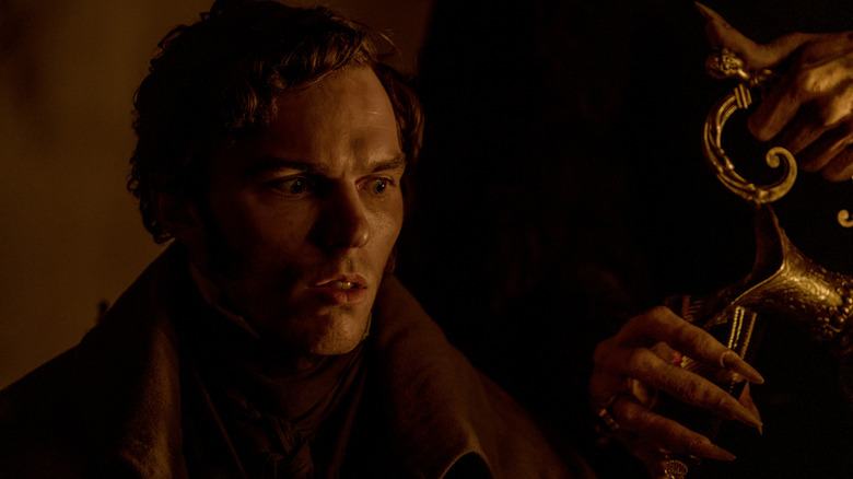 Nicholas Hoult looks concerned as Thomas Hutter looking at the hands of Nosferatu