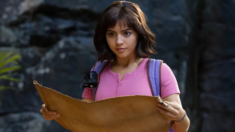 Isabela Merced as Dora, looking down at a map in Dora and the Lost City of Gold