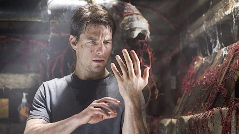 Ray Ferrier (Tom Cruise) examines a strange red substance in War of the Worlds (2005)