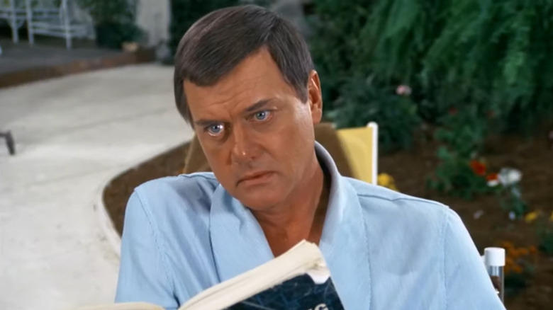 J.R. Ewing (Larry Hagman) looks up from his book in Dallas (1978)
