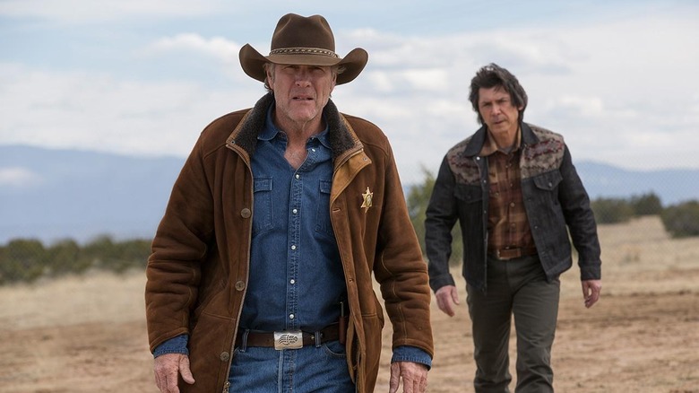Walt Longmire (Robert Taylor) walks outside ahead of Henry Standing Bear (Lou Diamond Phillips) in Longmire