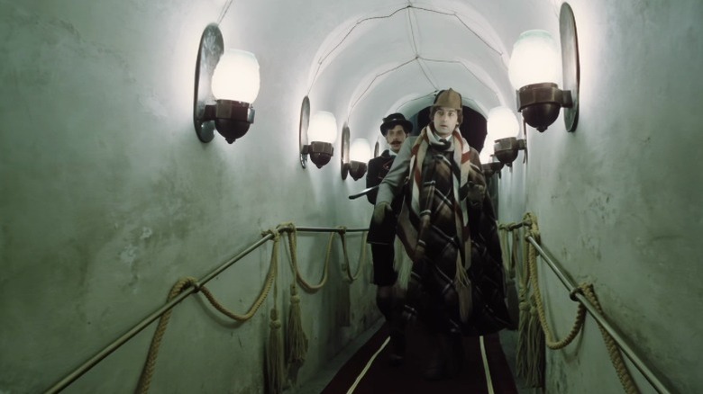 Jan Hartl as Vilja Dézi and Michal Dočolomanský as Count Teleke of Tölökö walking down a narrow arched corridor in The Mysterious Castle in the Carpathians