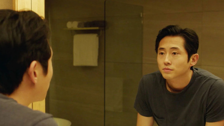Ben (Steven Yeun) examines himself in the mirror in Burning