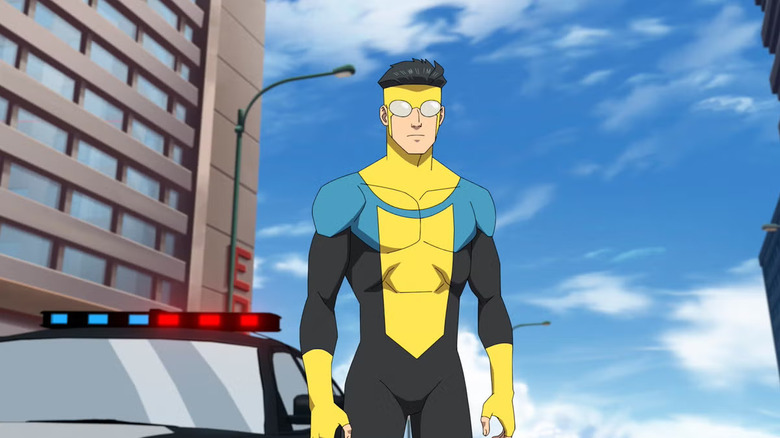 Mark (Steven Yeun) stands near a police car in Invincible