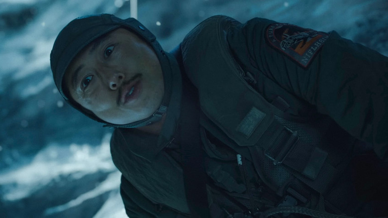 Timo (Steven Yeun) looks down in a tundra in Mickey 17
