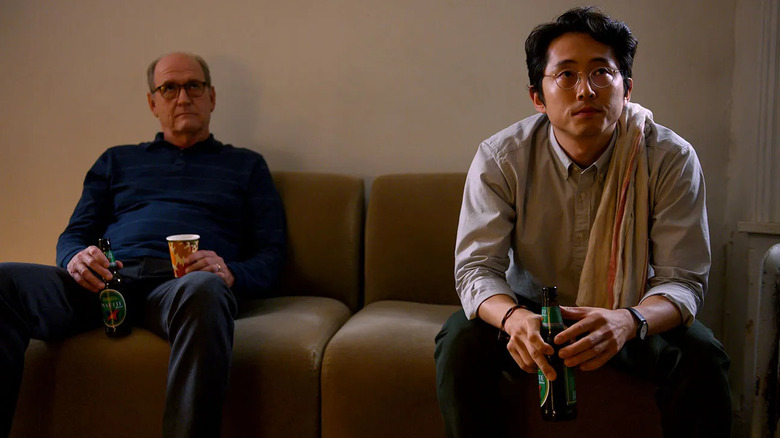 Erik (Richard Jenkins) and Blake (Steven Yeun) sit on a coach and contemplate in The Humans
