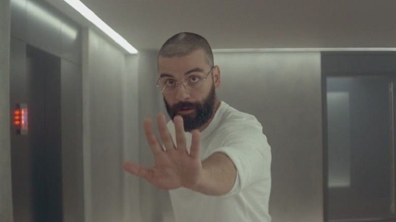 Oscar Isaac as Nathan Bateman in Ex Machina, holding his hand up in a "stop" stance at something past the camera.