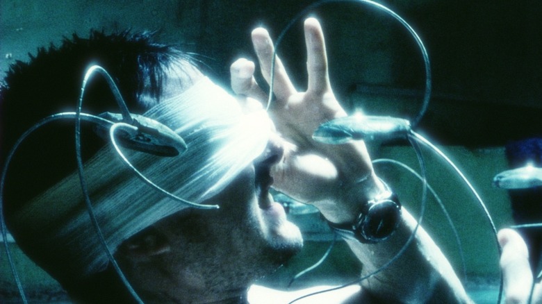 Tom Cruise as Chief John Anderton in Minority Report, gauze around his eyes and being prodded by small androids.
