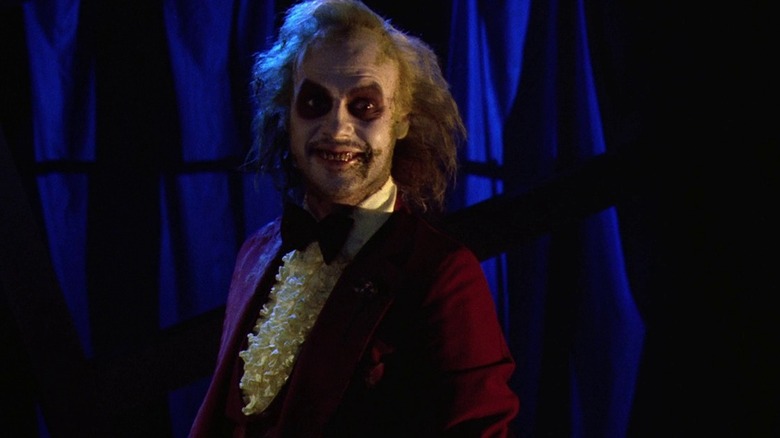 Betelgeuse (Michael Keaton) smiling while wearing a wedding suit in Beetlejuice