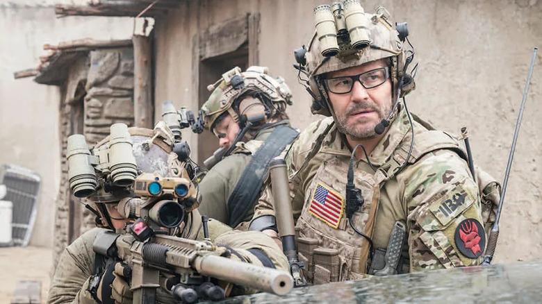 Master Chief Jason Hayes (David Boreanaz) watches a sniper take aim from behind a car in SEAL Team